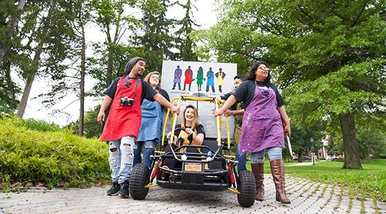 students walking with one in a saxon built racing buggy. 